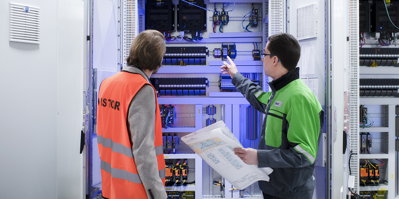 Valmet DNA Controllers and two people looking