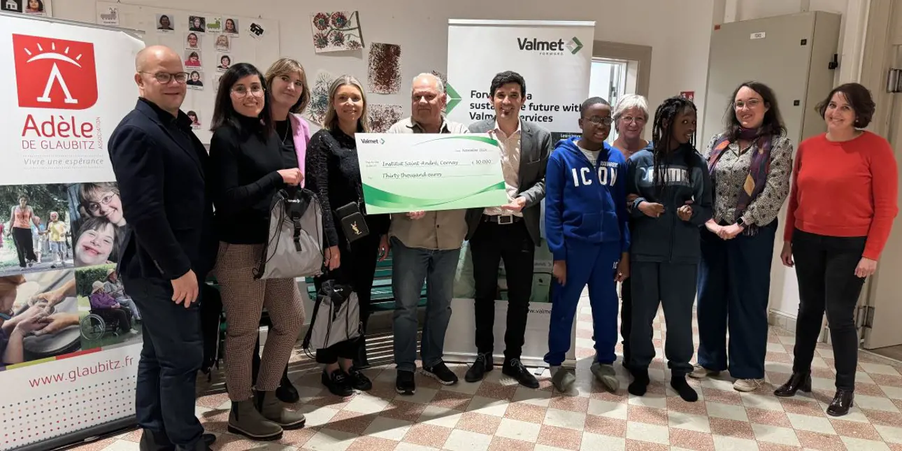 People in a group picture holding a sign of Valmet's donation