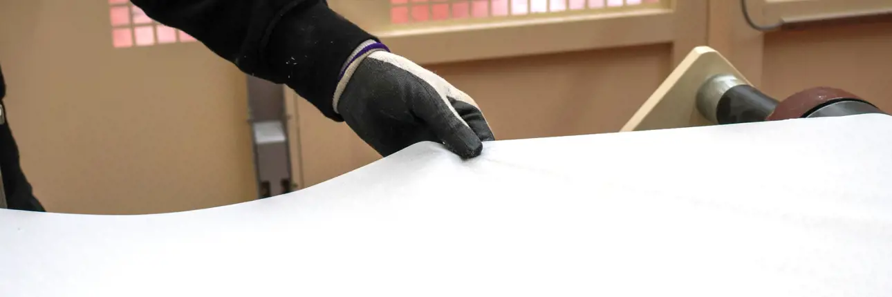 Tissue paper on a belt and a hand with a black glove touching it.